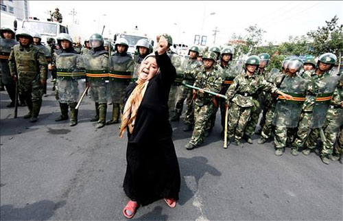 una mujer musulmana frente a un grupo de soldados Un millón de uigures detenidos en un campo de concentración secreto de China